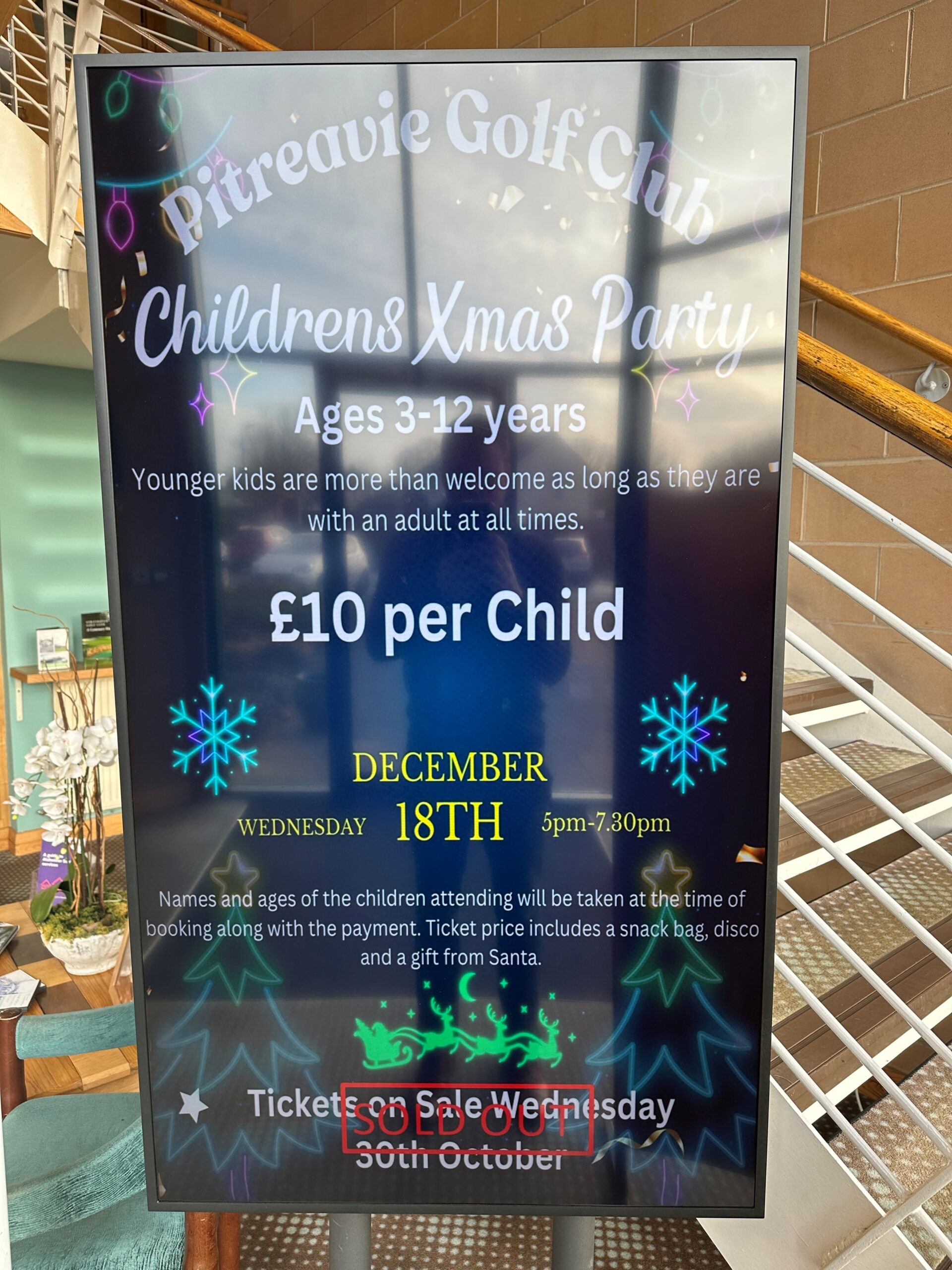 A Golf Club Screens display in the Pitreavie Golf Club clubhouse, promoting the club's Children's Christmas Party